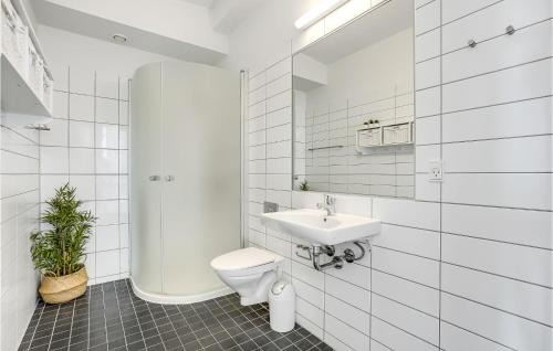 een witte badkamer met een toilet en een wastafel bij Amazing Apartment In Rm With Kitchen in Rømø Kirkeby