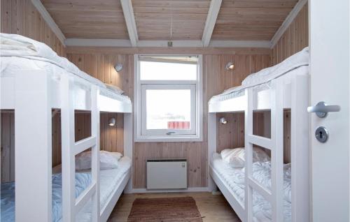 two bunk beds in a room with a window at Amazing Home In Hjrring With 3 Bedrooms, Sauna And Private Swimming Pool in Lønstrup