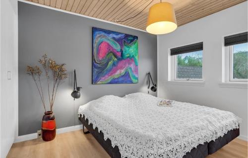 a bedroom with a bed and a painting on the wall at Nice Home In Skagen With Wifi in Skagen
