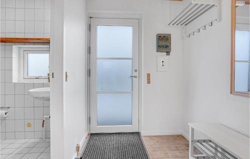 La salle de bains blanche est pourvue d'une porte et d'un lavabo. dans l'établissement Nice Home In Skagen With Wifi, à Skagen