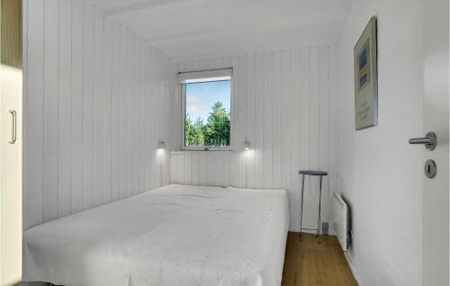 a white bedroom with a bed and a window at Beautiful Home In Skagen With 3 Bedrooms, Sauna And Wifi in Hulsig