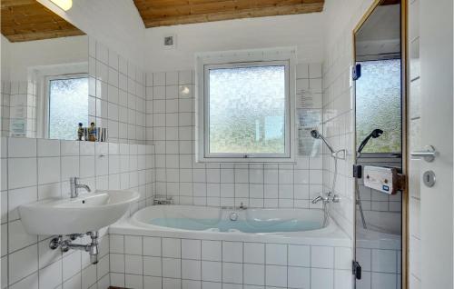 a white bathroom with a tub and a sink at Beautiful Home In Skagen With 3 Bedrooms, Sauna And Wifi in Hulsig