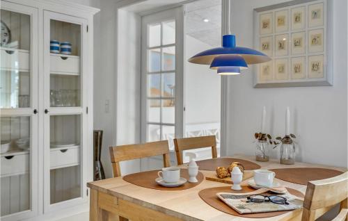 スケーエンにあるBeautiful Home In Skagen With 1 Bedrooms And Wifiのダイニングテーブル(青いペンダントライト付)