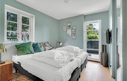 un grande letto in una stanza con due finestre di 3 Bedroom Lovely Home In Skagen a Skagen