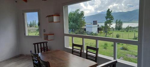 a dining room with a table and a large window at Al Paraíso in Tafí del Valle