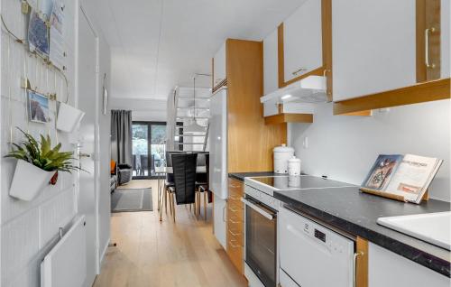 a kitchen with white cabinets and a black counter top at 2 Bedroom Cozy Apartment In Blokhus in Blokhus
