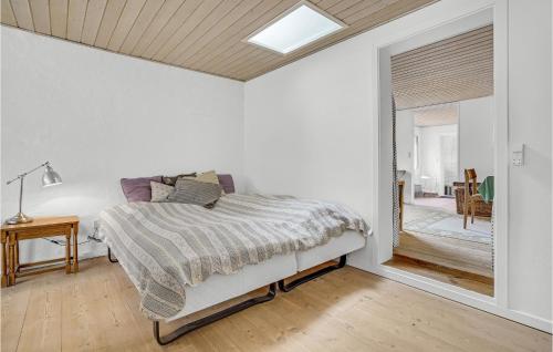 ein weißes Schlafzimmer mit einem Bett und einem Fenster in der Unterkunft Gorgeous Apartment In Blokhus With Kitchen in Blokhus