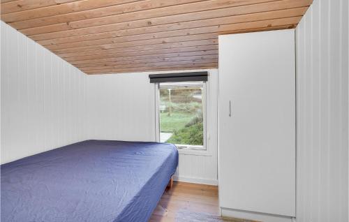 a bedroom with a bed and a window at Holiday Home Harrerenden Hjørring Iii in Lønstrup