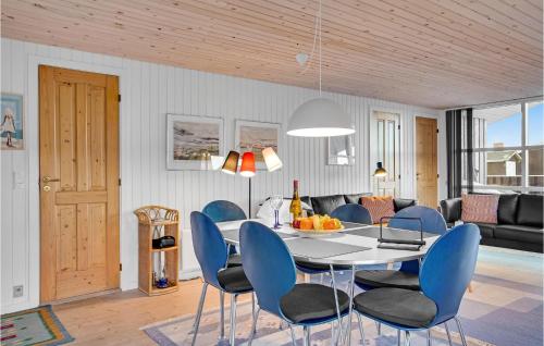 a dining room with a table and blue chairs at Holiday Home Harrerenden Hjørring Iii in Lønstrup