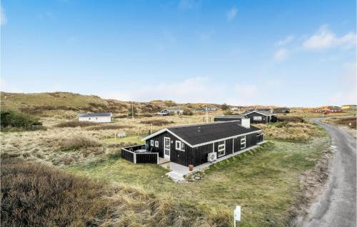 a small black house on the side of a road at Holiday Home Harrerenden Hjørring Iii in Lønstrup