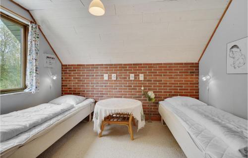 Zimmer mit 2 Betten und Ziegelwand in der Unterkunft Nice Home In Lkken With Wifi in Lønstrup
