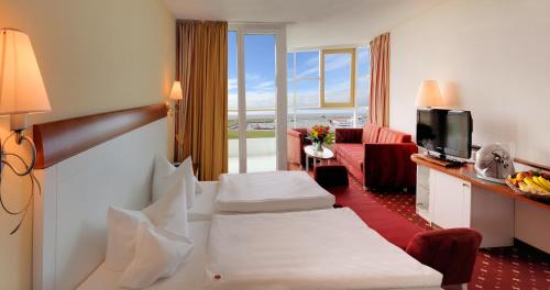 a hotel room with two beds and a television at Hotel Fährhaus in Norddeich