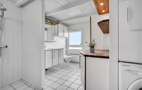 a white bathroom with a toilet and a sink at Nice Home In Bindslev With 4 Bedrooms, Sauna And Indoor Swimming Pool in Bindslev