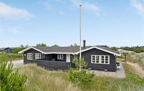 a black house in the middle of a field at Three-Bedroom Holiday Home In Skagen in Skagen
