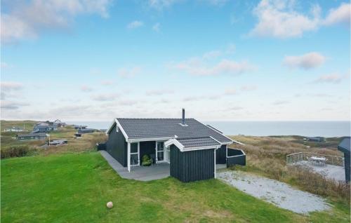 a house on the beach with the ocean in the background at Holiday Home Klitbakkevej in Lønstrup