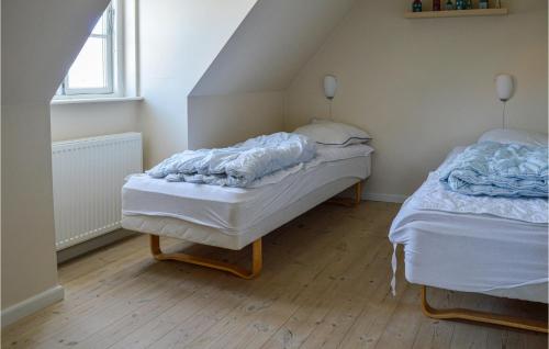 two twin beds in a room with a attic at Awesome Home In Skagen With Kitchen in Skagen