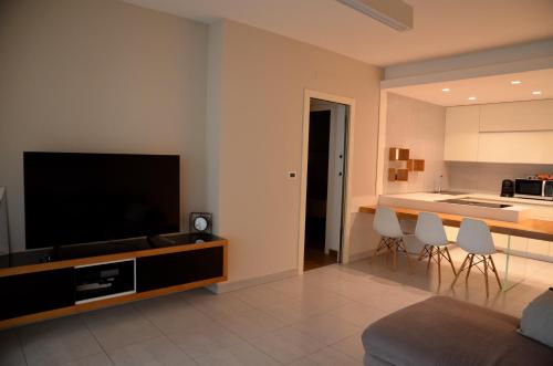 モンテジルヴァーノにあるappartamento libraのリビングルーム(薄型テレビ付)、キッチンが備わります。