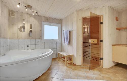 SaltumにあるBeautiful Home In Saltum With 4 Bedrooms, Sauna And Wifiのバスルーム(大型バスタブ、シャワー付)