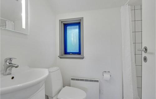 a bathroom with a toilet and a sink and a window at Cozy Home In Hjrring With Sauna in Lønstrup