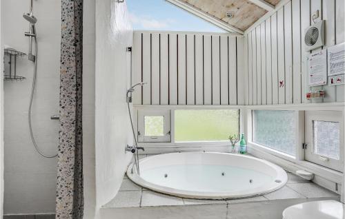 uma banheira branca na casa de banho com uma janela em Cozy Home In Bindslev With Wifi em Bindslev