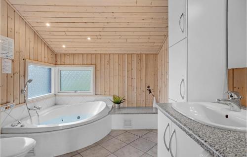 y baño con bañera y lavamanos. en Awesome Home In Lkken With 4 Bedrooms, Sauna And Wifi, en Løkken