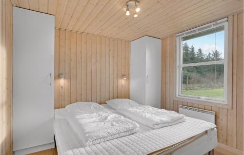 Cama blanca en habitación con ventana en Awesome Home In Lkken With 4 Bedrooms, Sauna And Wifi, en Løkken