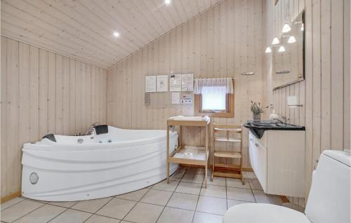 ein Badezimmer mit einer Badewanne und einem Waschbecken in der Unterkunft 3 Bedroom Stunning Home In Lkken in Grønhøj