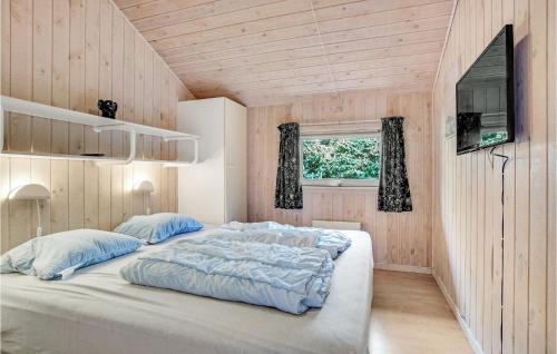 ein großes Bett in einem Zimmer mit Holzwänden in der Unterkunft 3 Bedroom Stunning Home In Lkken in Grønhøj
