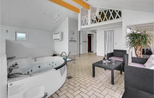 Grønhøjにある4 Bedroom Stunning Home In Lkkenの広いバスルーム(バスタブ付)、リビングルームが備わります。