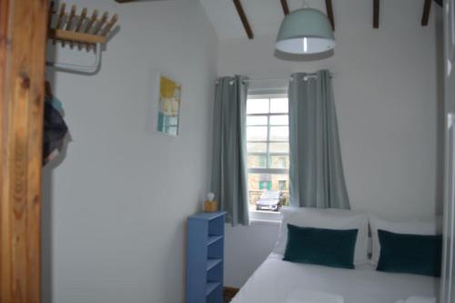 una camera con un letto bianco e una finestra di 2-bedroom cottage in heart of St Ives w/ parking a St Ives