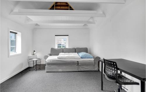 5 Bedroom Amazing Home In Strandby في Strandby: غرفة بيضاء مع سرير وطاولة