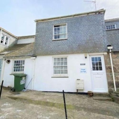 una casa bianca con tetto grigio di 2-bedroom cottage in heart of St Ives w/ parking a St Ives