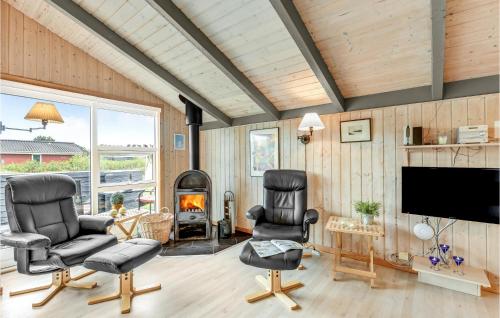 a living room with two chairs and a flat screen tv at Amazing Home In Hvide Sande With Wifi in Bjerregård