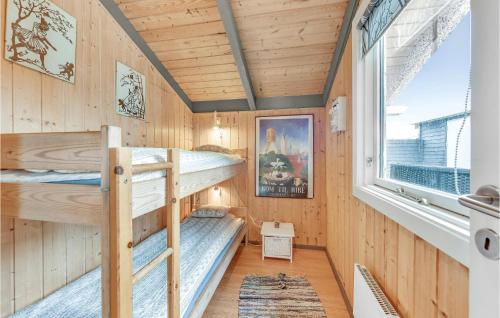 BjerregårdにあるBeautiful Home In Hvide Sande With Kitchenの二段ベッド2台と窓が備わる客室です。