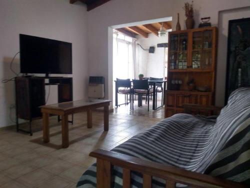 sala de estar con TV y comedor en Mendoza casa para turistas en Mendoza