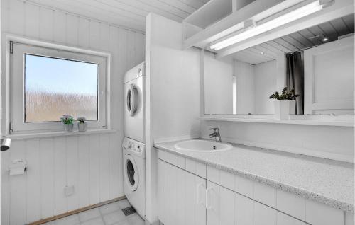 BjerregårdにあるLovely Home In Hvide Sande With Saunaの白いバスルーム(シンク、洗濯機付)