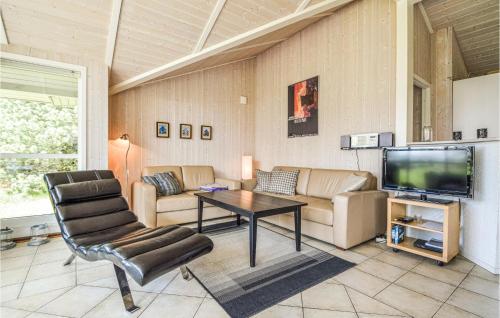 a living room with a couch and a tv at Holiday Home Gl Mælkevej Xii in Blåvand