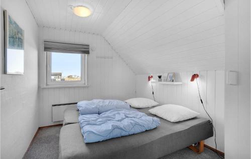 BjerregårdにあるLovely Home In Hvide Sande With Saunaのベッドルーム1室(ベッド2台、窓付)