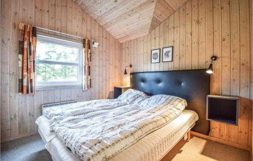 a bedroom with a bed and a television in it at Stunning Home In Blvand With 4 Bedrooms, Sauna And Wifi in Blåvand