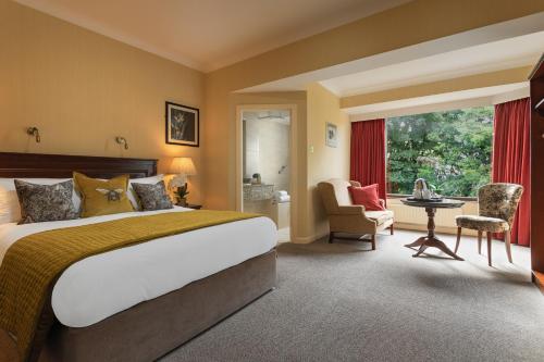 um quarto de hotel com uma cama, uma mesa e cadeiras em The Ardilaun Hotel em Galway