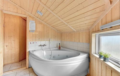 スナーヴィグにあるPet Friendly Home In Ringkbing With House A Panoramic Viewの木製天井の客室で、白い大型バスタブが備わります。