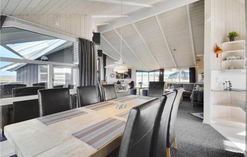 a dining room with a wooden table and chairs at Holiday Home Arvidvej Denm in Bjerregård