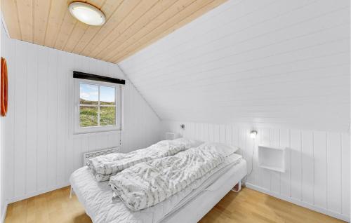Nørre LyngvigにあるBeautiful Home In Ringkbing With Indoor Swimming Poolの白いベッドルーム(ベッド1台、窓付)