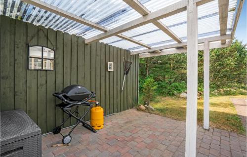 a green house with a grill and a pergola at Amazing Home In Hvide Sande With Sauna in Bjerregård