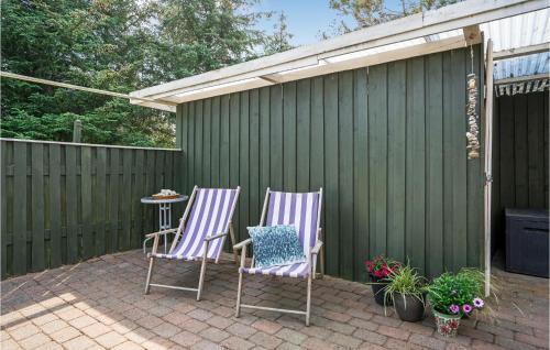 two chairs and a table on a patio at Amazing Home In Hvide Sande With Sauna in Bjerregård
