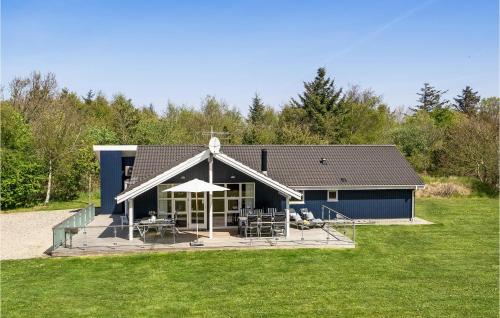 リンケビングにあるFour-Bedroom Holiday Home In Ringkobingのブルーハウス デッキ(椅子、パラソル付)