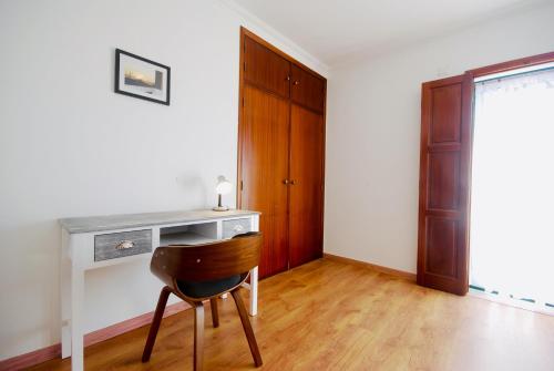 a desk with a chair in a room with a door at Catarina House - Baleal Beach, Balcony, Pool in Ferrel