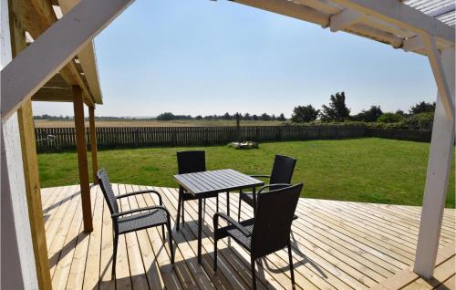 a patio with a table and chairs on a deck at Awesome Home In Harboøre With Kitchen in Harboør