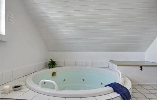 クリムトラにあるAmazing Home In Thisted With 4 Bedrooms, Sauna And Wifiの白いバスルーム(バスタブ付)が備わります。
