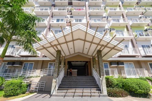 a building with stairs leading to the front entrance at 537 AMANI LUXURY SUITE, 3 Minutes to Airport,with Gym & Pool, FAST WI-FI, Free Netflix in Pusok